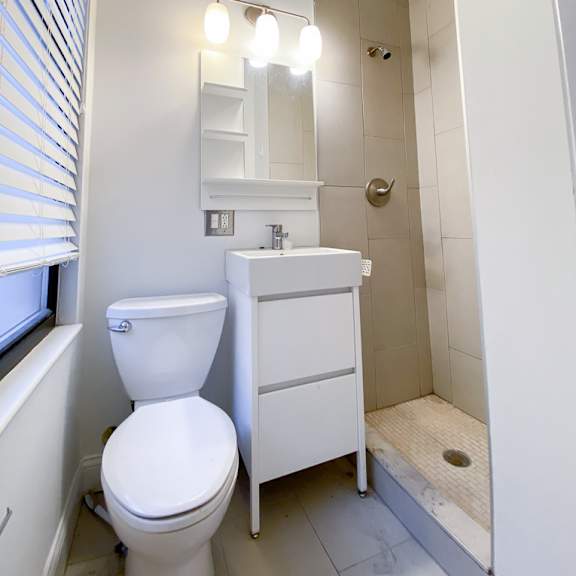 a white toilet sits next to a sink in a small bathroom.