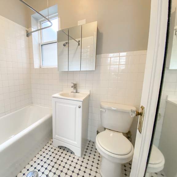 a white bathroom with a black and white checkered floor.