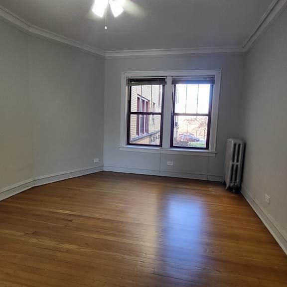a living room with a window and wooden floors