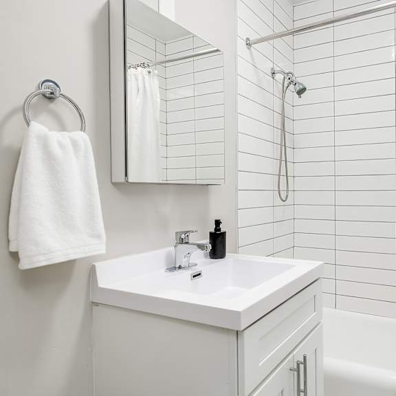 a white bathroom with a white sink and a white shower curtain.