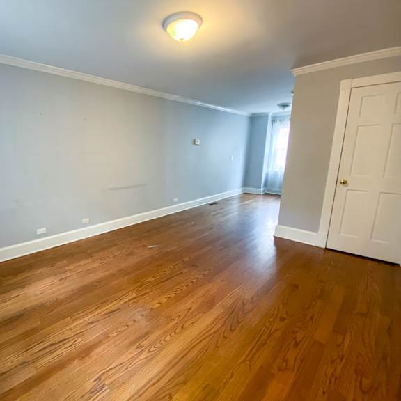 a living room with wooden floors and a white door