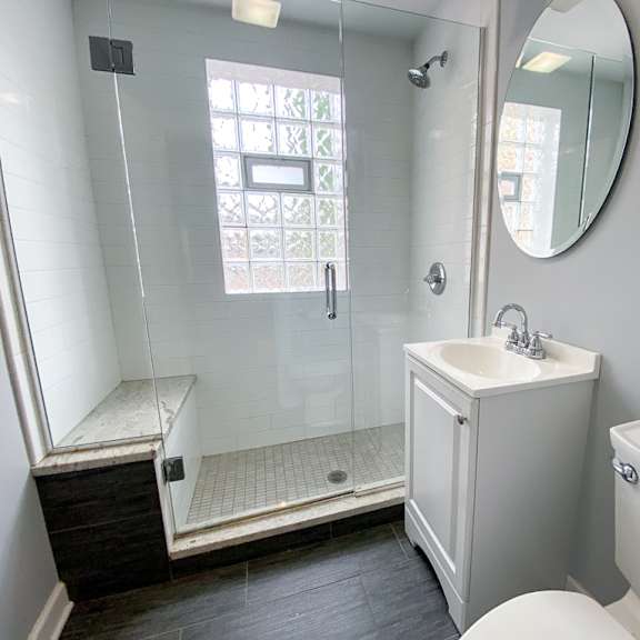 a bathroom with a shower and a sink and a toilet