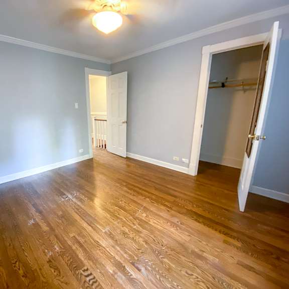 a living room with a hard wood floor and a door to a closet