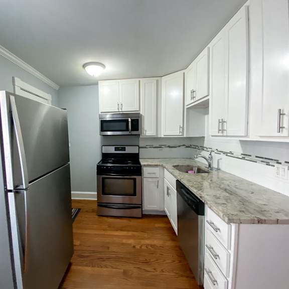 a kitchen with stainless steel appliances and white cabinets