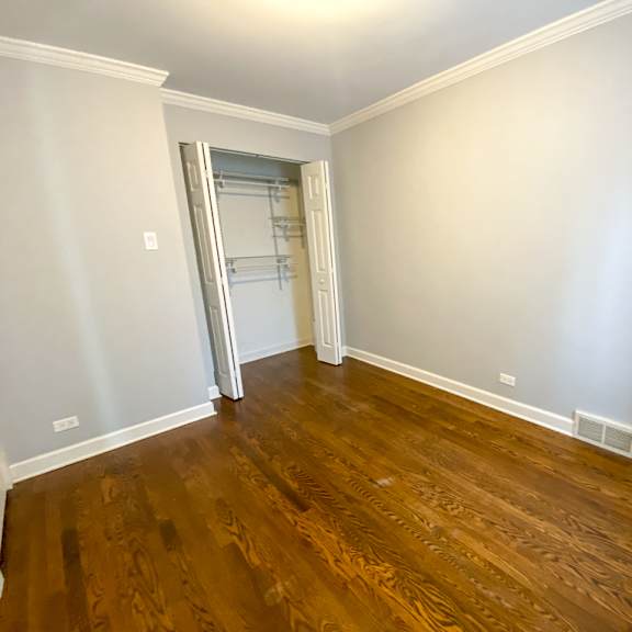 a empty living room with wooden floors and a closet