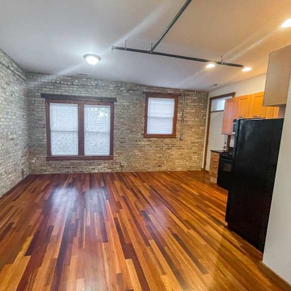 a room with wooden floors and a brick wall.