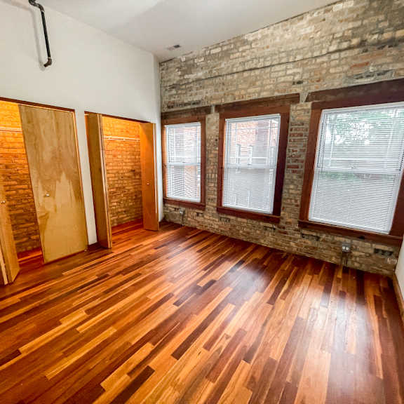a room with wooden floors and a brick wall.