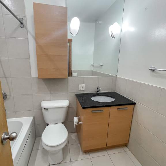 a bathroom with a toilet, sink, and mirror.