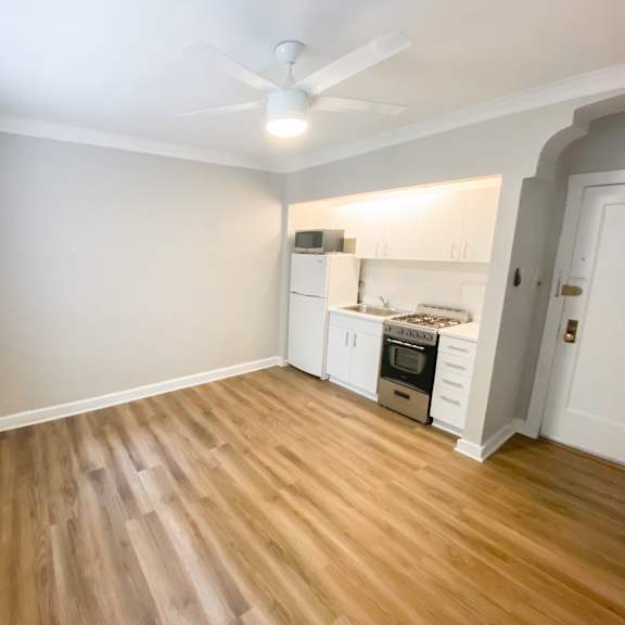 a room with a wood floor and a ceiling fan.