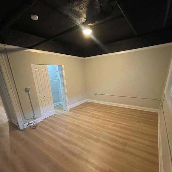 the living room has a hard wood floor and a black ceiling