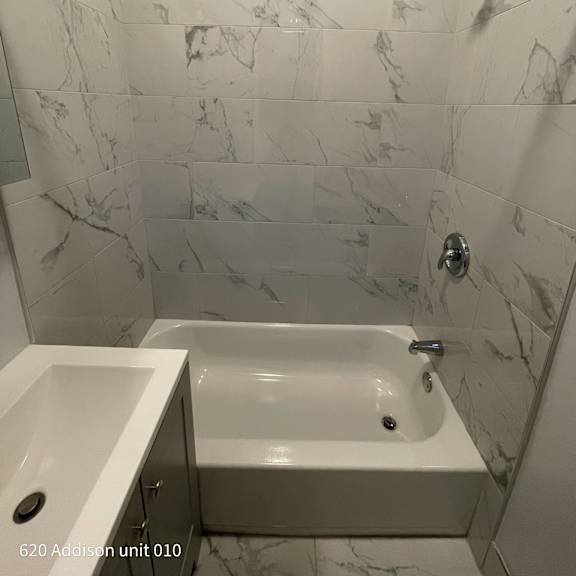 a white bathroom with a tub and a sink