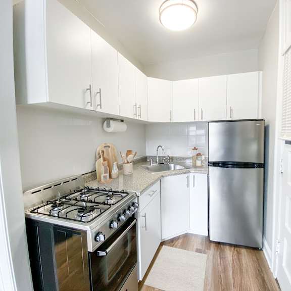 a kitchen with a stove, refrigerator, and cabinets.