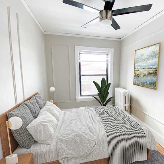 a bedroom with a bed, a ceiling fan, and a painting on the wall.