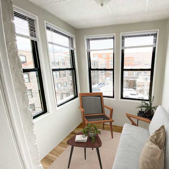 a living room with a couch, chair, and a table with a plant on it.
