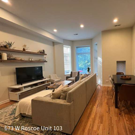 a living room with a couch, a television, and a fireplace.
