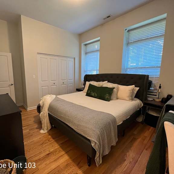 a bedroom with a bed, dresser, and television.
