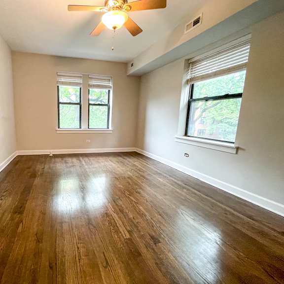 a room with wooden floors and a ceiling fan.