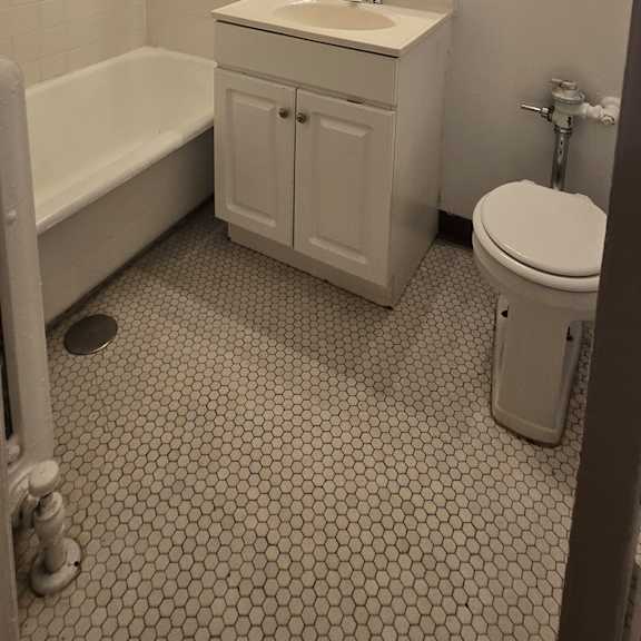 a bathroom with a toilet, sink, and mirror.