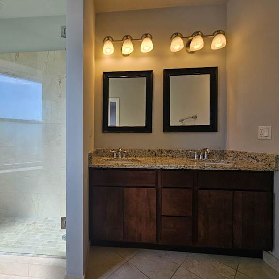 a bathroom with a sink and a shower and a mirror