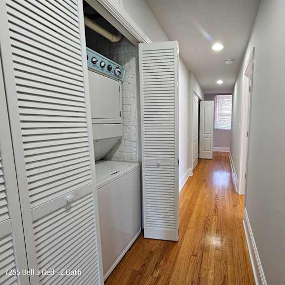 a laundry room with a washer and dryer and a hall to a bathroom