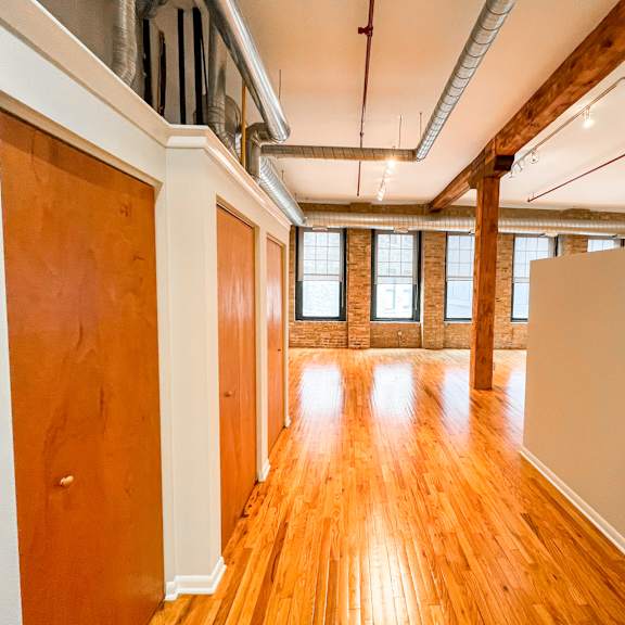 a long hallway with wooden floors and white walls.