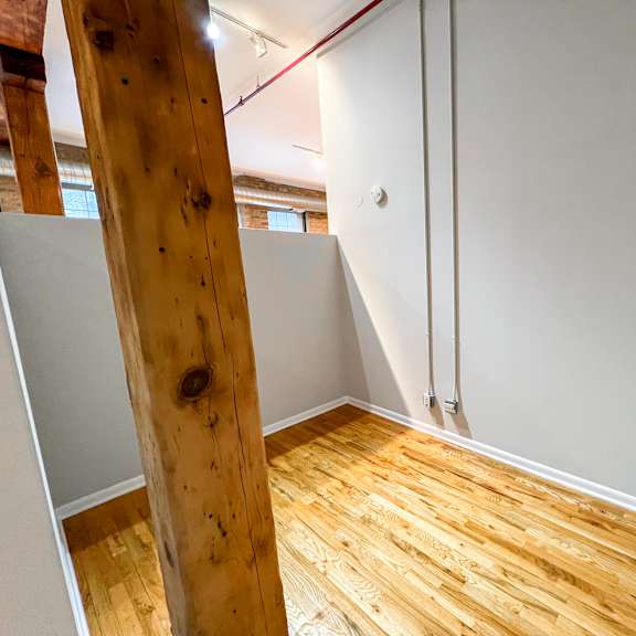 a room with a wooden floor and a white wall.