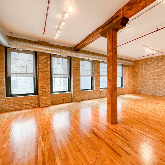 a room with wooden floors and a brick wall.