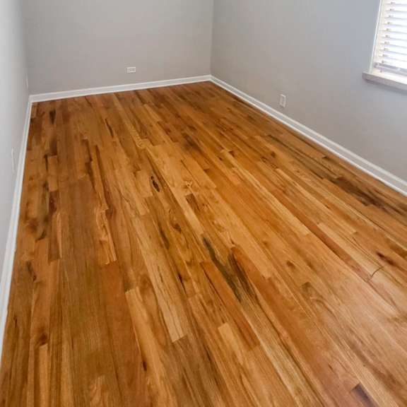 a room with wooden flooring and a ceiling light.