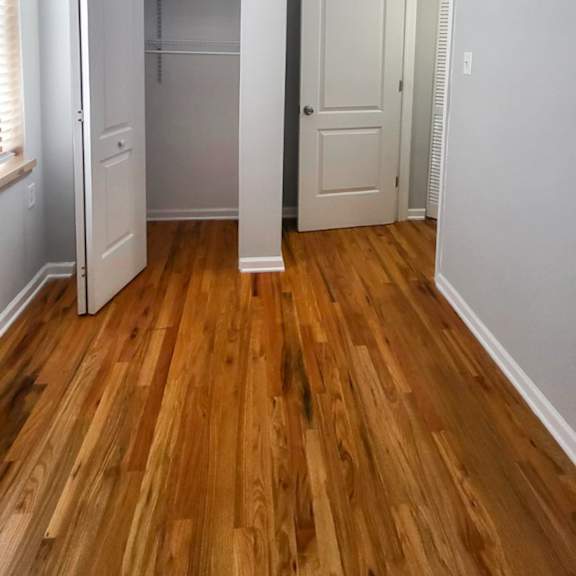 a room with a white door and a white closet with a white shelf.