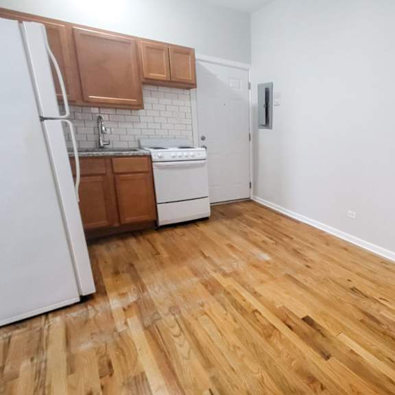 a kitchen with wooden floors and white walls.
