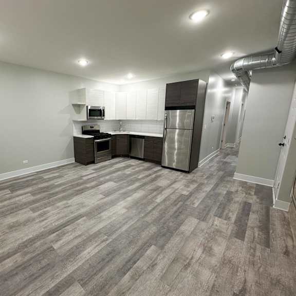 a kitchen area with a refrigerator, microwave, and oven.