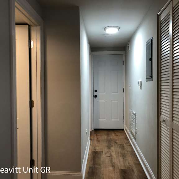 a hallway with a white door and a light on the ceiling.
