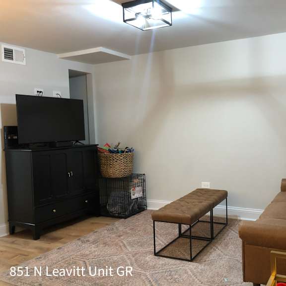 a living room with a brown couch, a black cabinet, and a flat screen tv.