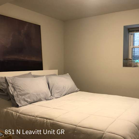 a bedroom with a bed, pillows, and a window.