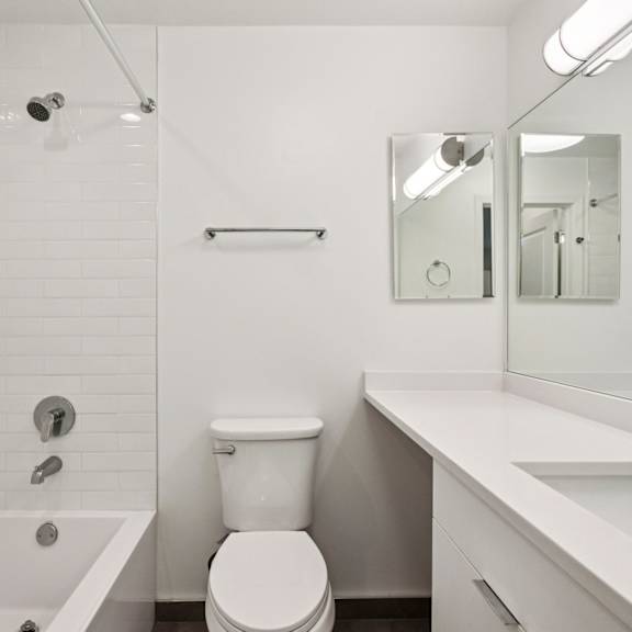 a white bathroom with a toilet, sink, and bathtub.
