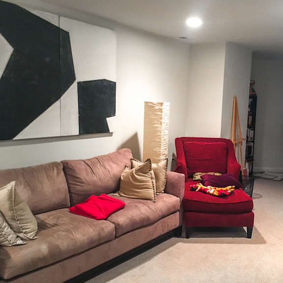 a living room with a brown couch and a red chair.