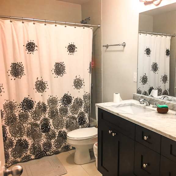 a bathroom with a toilet, sink, and shower curtain.