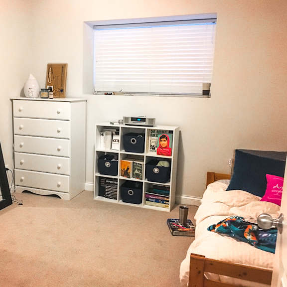 a bedroom with a bed, dresser, and a mirror.