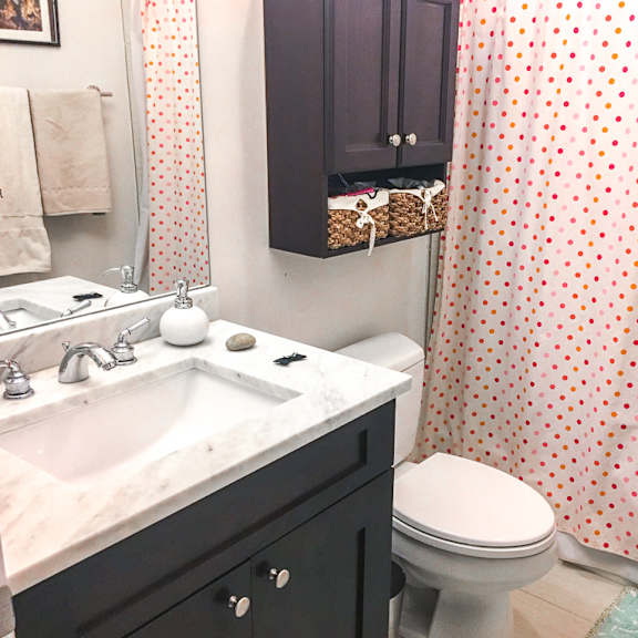 a bathroom with a toilet, sink, and shower curtain.