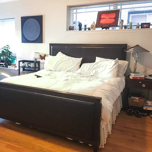 a bedroom with a large bed and a desk with a chair.