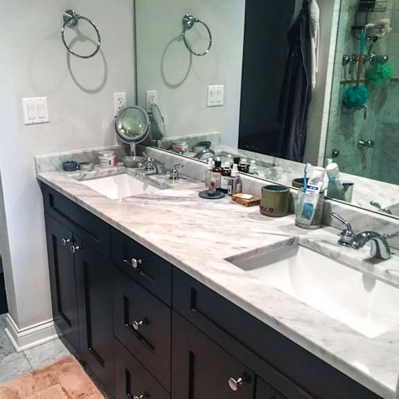 a bathroom with a marble countertop and a white sink.