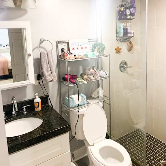 a bathroom with a toilet, sink, and a shower with a glass door.