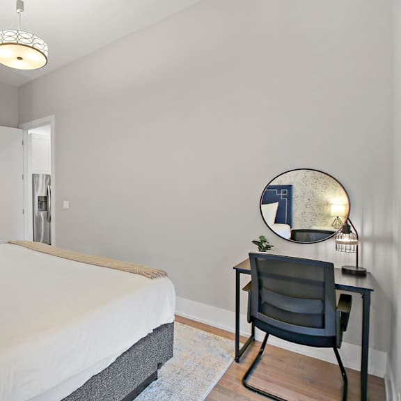 a bedroom with a bed and a desk with a chair