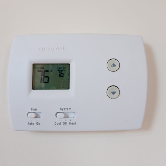 a honeywell thermostat with a digital display showing 75 degrees.