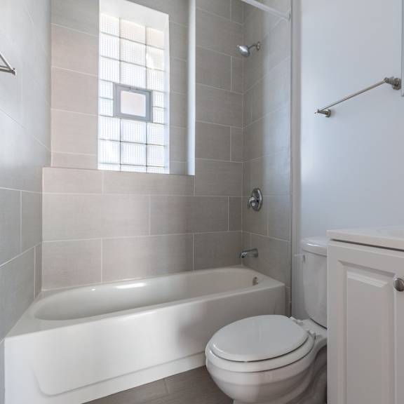 a white bathroom with a tub, toilet and sink.
