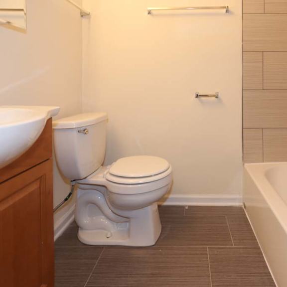 a white toilet sits next to a white sink in a small bathroom.