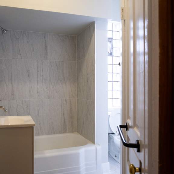 a bathroom with a white tub and sink.