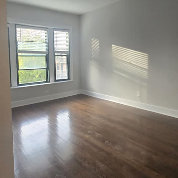 a room with wooden floors and a window letting in light.