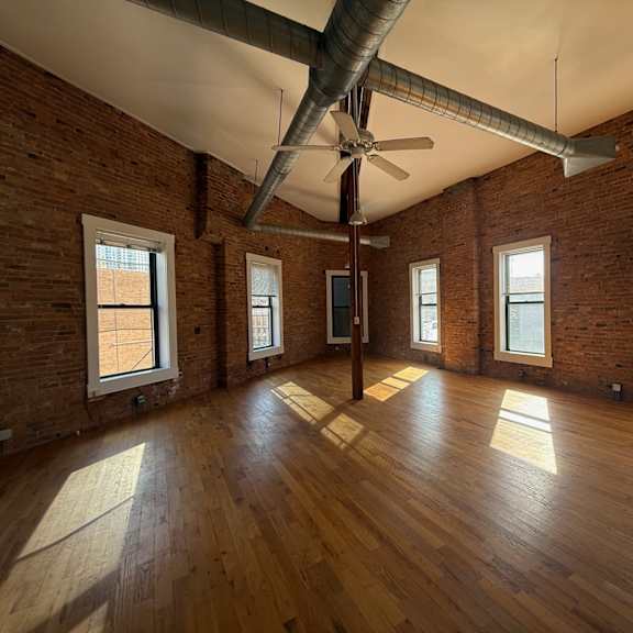 a room with wooden floors and a ceiling fan.