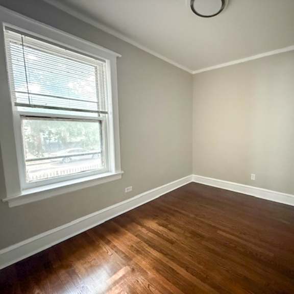 a room with a window and a wooden floor.